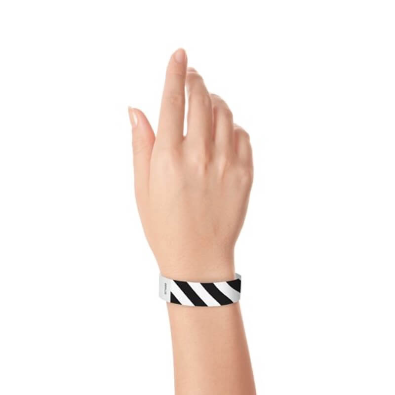 hand wearing white tyvek wristband with black diagonal stripes