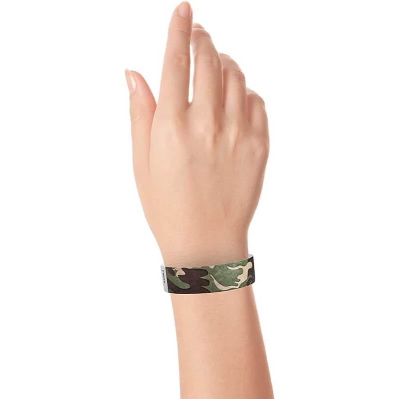 wrist wearing a camouflage patterned tyvek wristband greens and browns