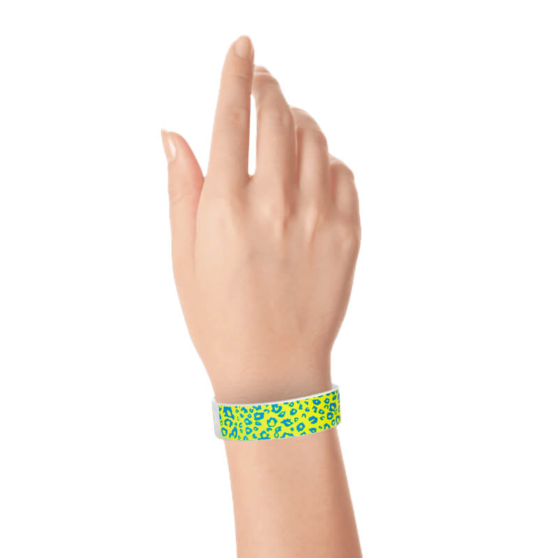 Hand wearing aqua and neon yellow cheetah patterned tyvek wristband
