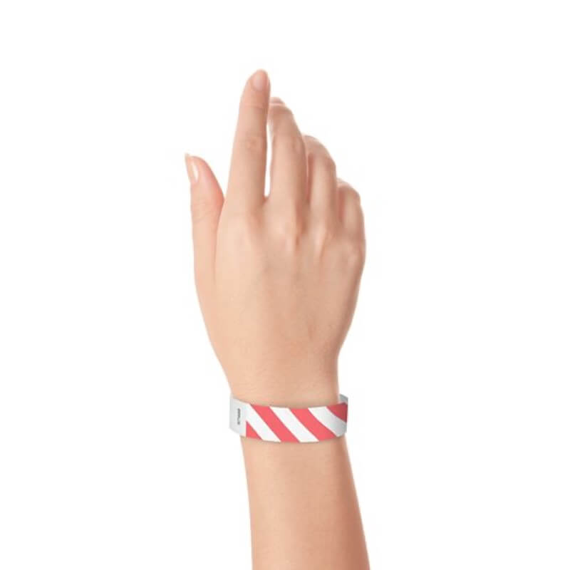 hand wearing white tyvek wristband with coral red diagonal stripes