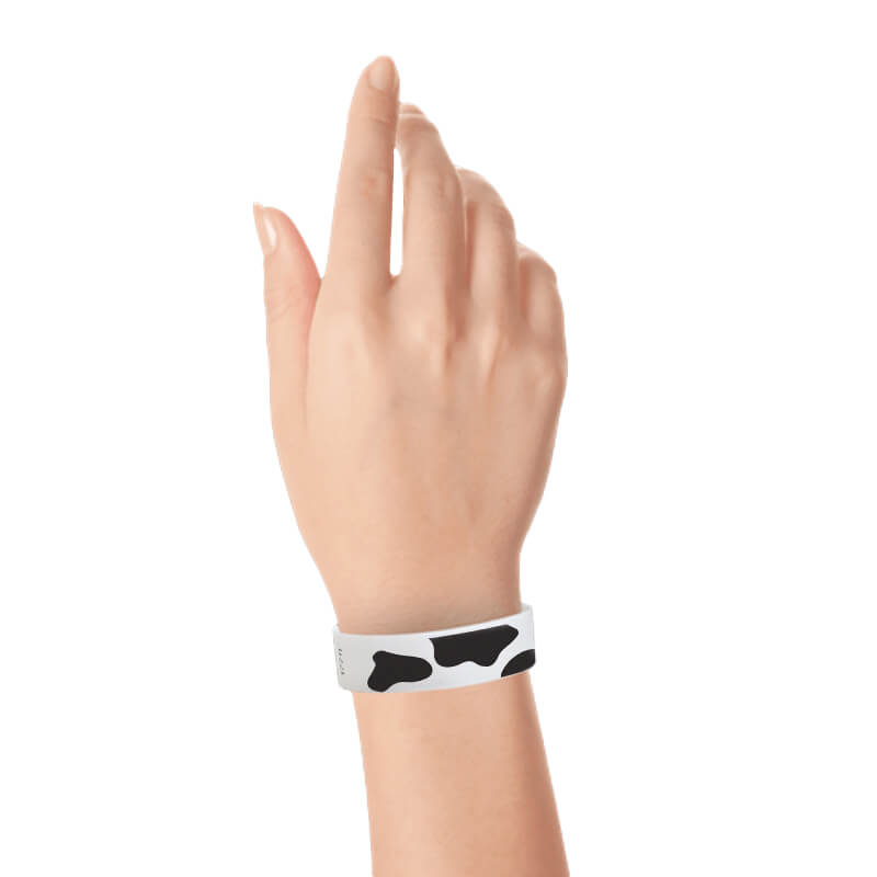 Wrist wearing a cow print tyvek wristband