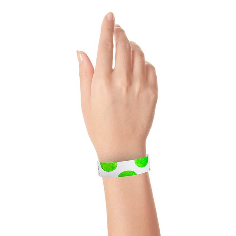 hand wearing a white tyvek wristband with neon green half circles