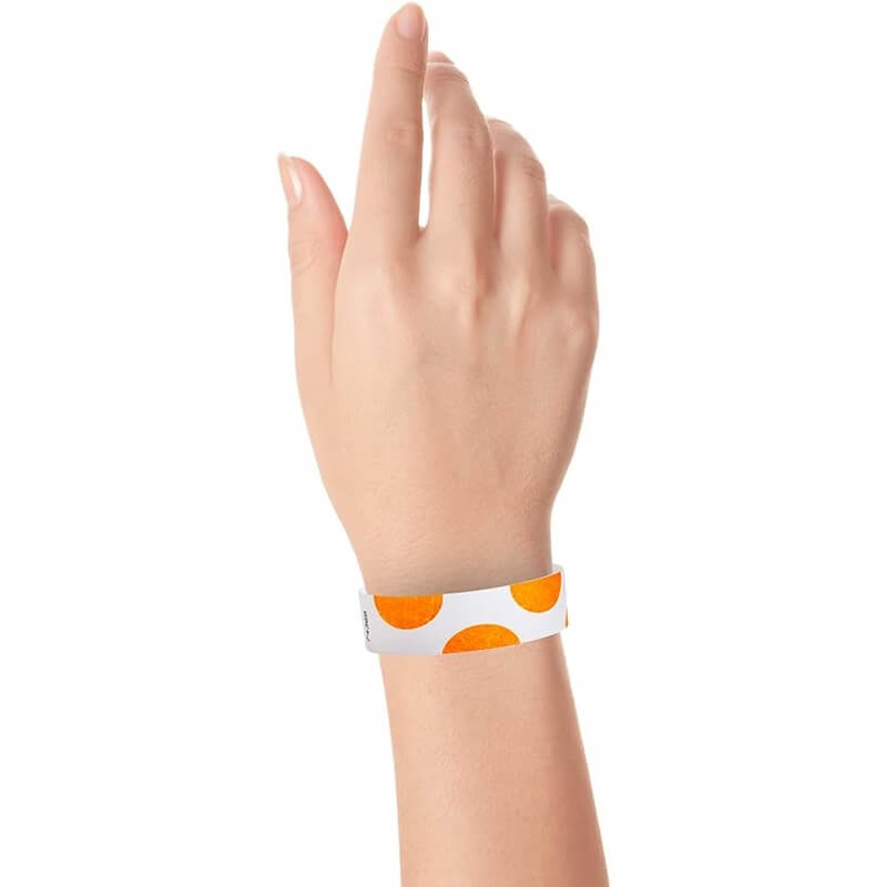 hand wearing a white tyvek wristband with neon orange half circles