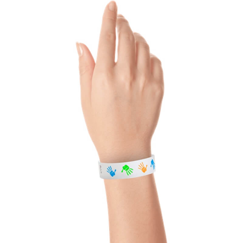 wrist wearing a white tyvek wristbandwith neon blue, neon green and neon orange handprints repeated