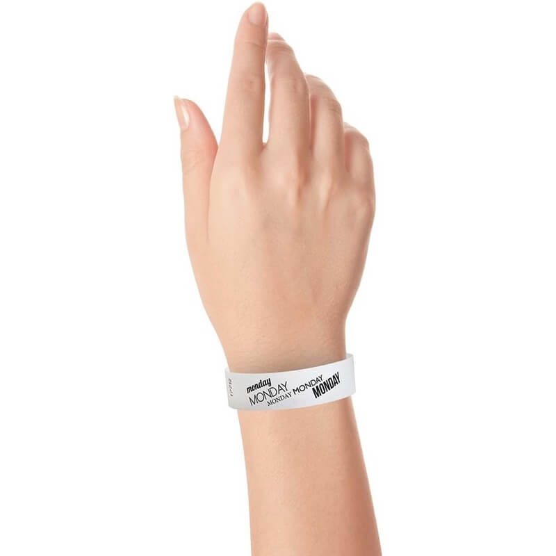 hand wearing white tyvek wristband with monday text in black ink repeated