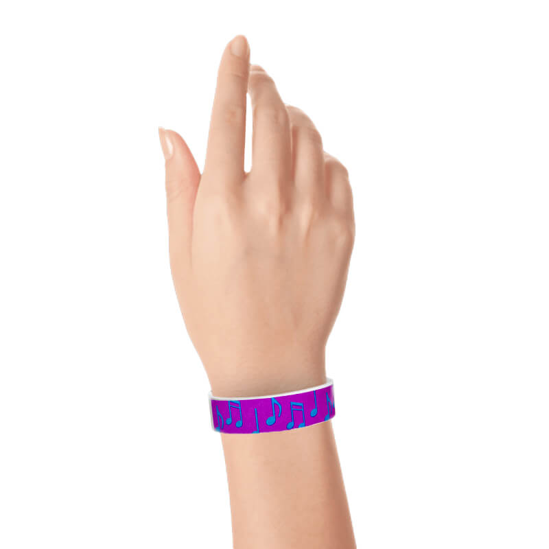 hand wearing a pantone purple tyvek wristband with a music note pattern in neon blue