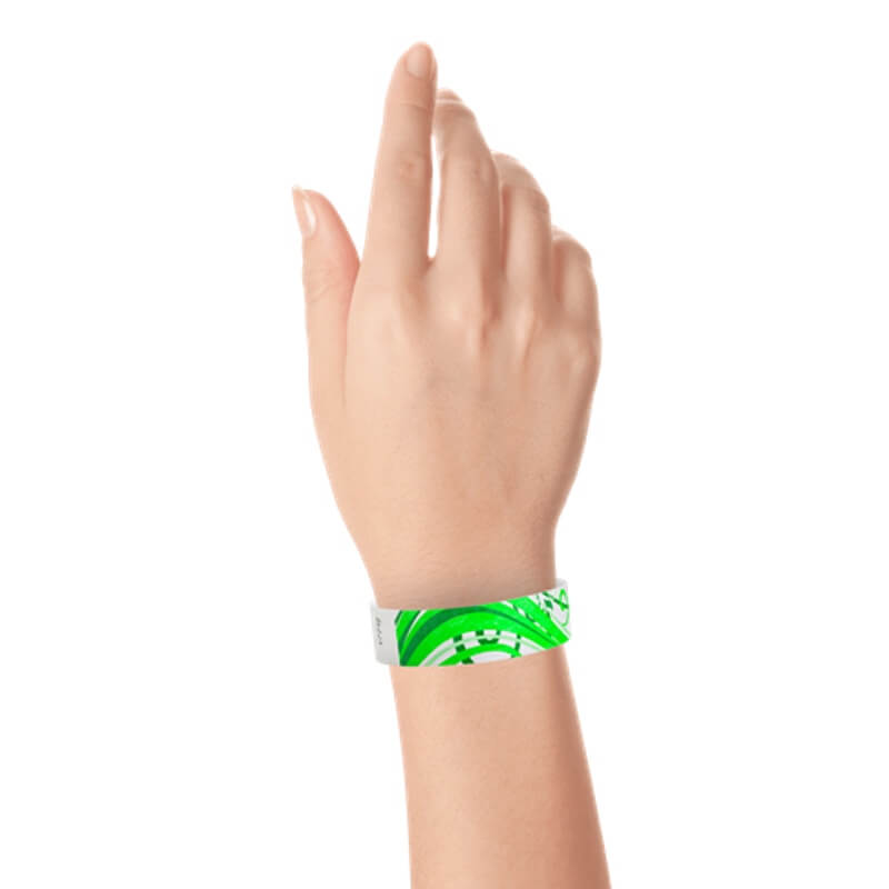 wrist wearing a white tyvek wristband with neon green and kelly green nature pattern