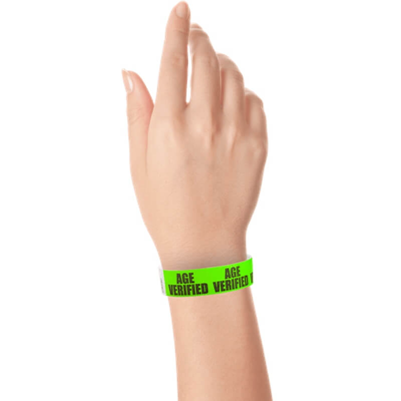 hand wearing a neon green tyvek wristband with age verified text repeated across the band