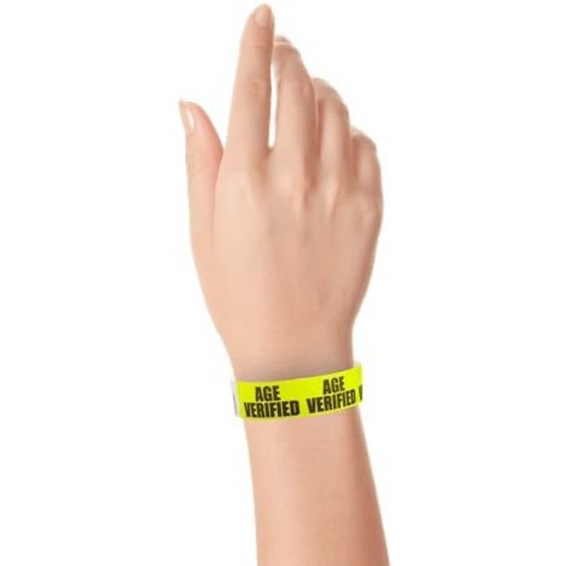hand wearing neon yellow tyvek wristband with age verified text