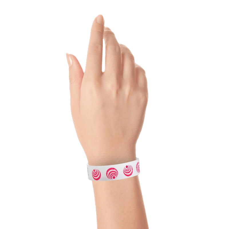 wrist wearing a white tyvek wristband with neon red circle patterns spinning