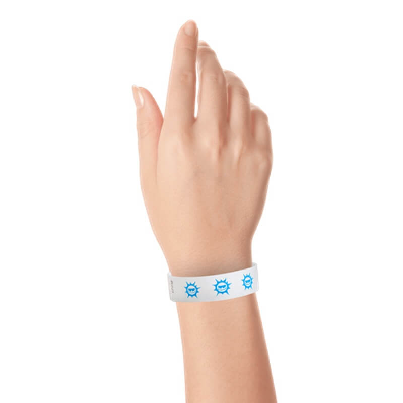 hand wearing white tyvek wristband with neon blue sun pattern repeated