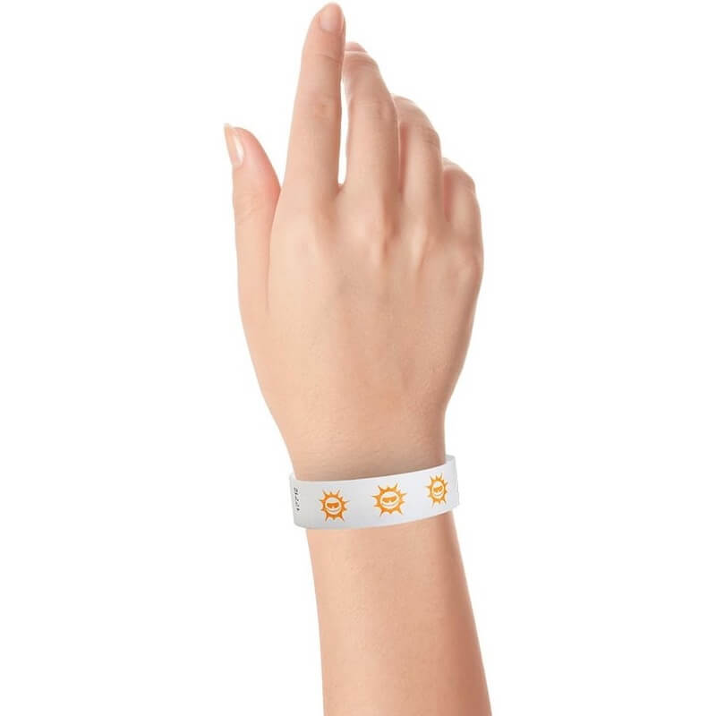hand wearing white tyvek wristband with neon orange sun pattern repeated