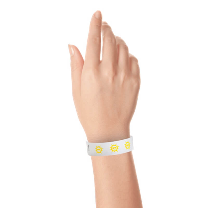 hand wearing white tyvek wristband with pantone yellow sun pattern repeated