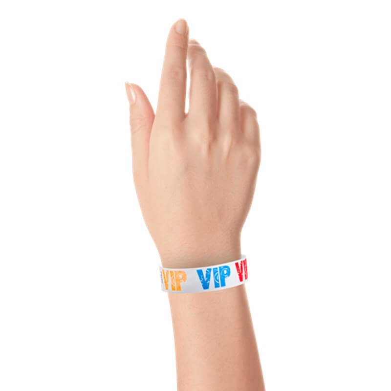 wrist wearing a white tyvek wristbands with VIP printed in neon red, neon blue and neon orange