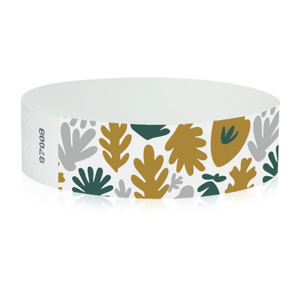 White wristband with colourful leaf pattern in gold, silver and green - round version shown 