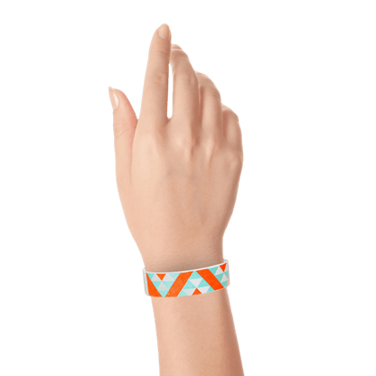 Wrist with aqua and neon orange aztec pattern on a white tyvek wristband 