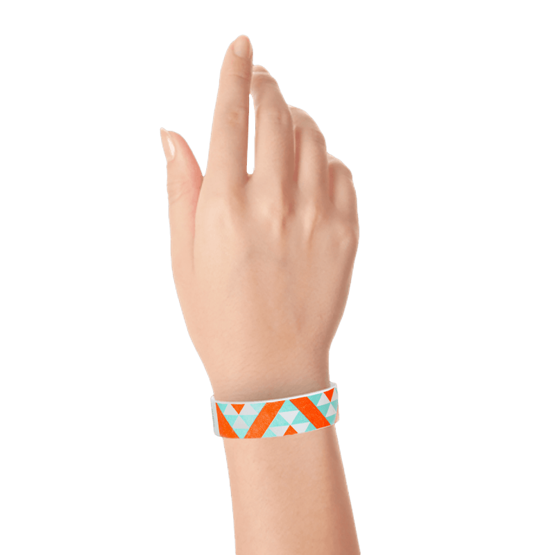 Wrist with aqua and neon orange aztec pattern on a white tyvek wristband 