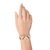 Wrist with aqua and neon orange aztec pattern on a white tyvek wristband 