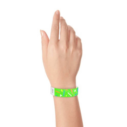 wrist wearing a neon green tyvek wristband in a confetti pattern with neon orange, neon blue, neon yellow and white