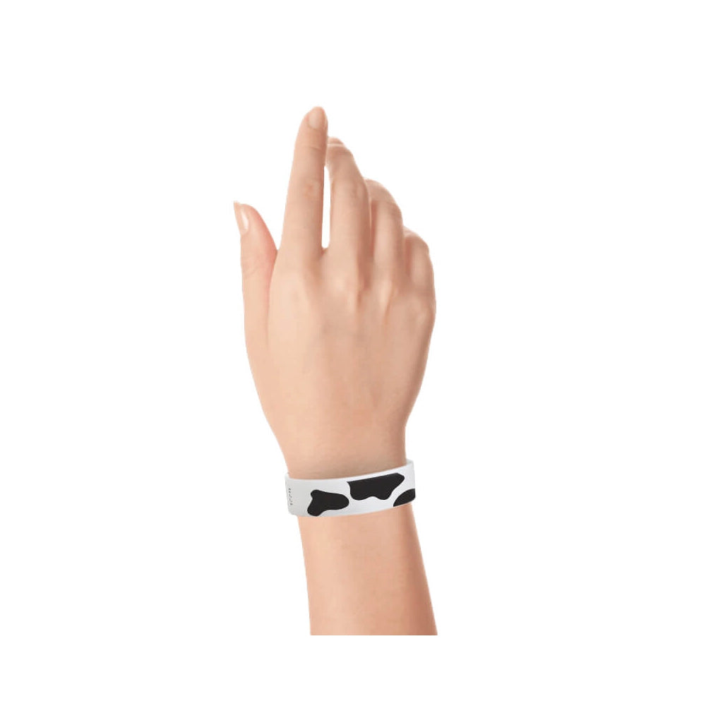 Wrist wearing a cow print tyvek wristband