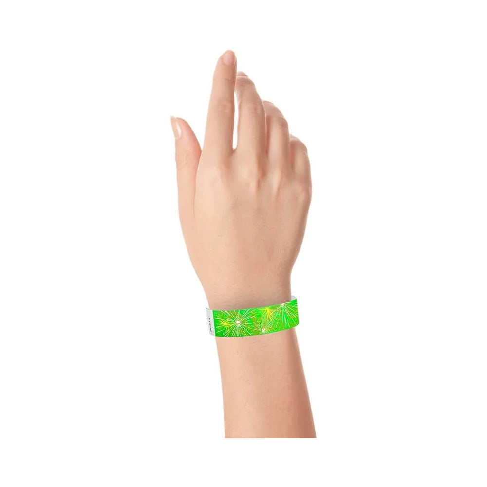 wrist wearing a neon green tyvek wristband with a fireworks pattern in neon yellow, neon orange and white