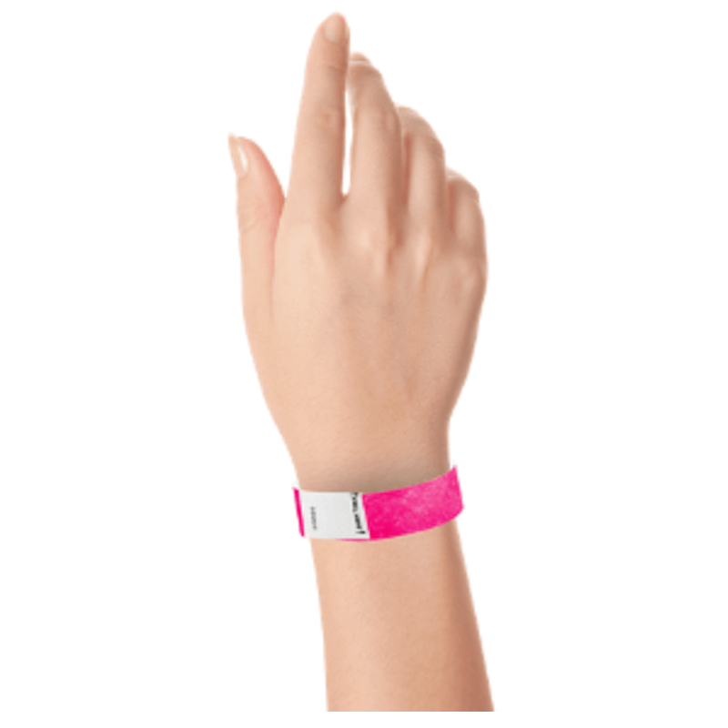 hand wearing a litter free tyvek 3/4" wristband in neon pink
