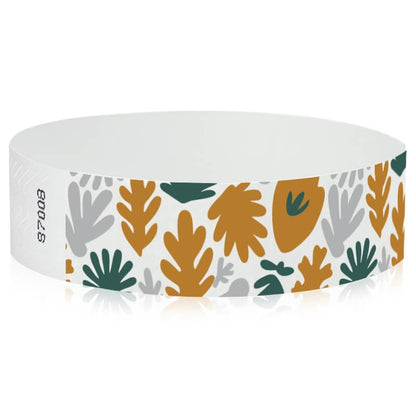 White wristband with colourful leaf pattern in gold, silver and green - round version shown 