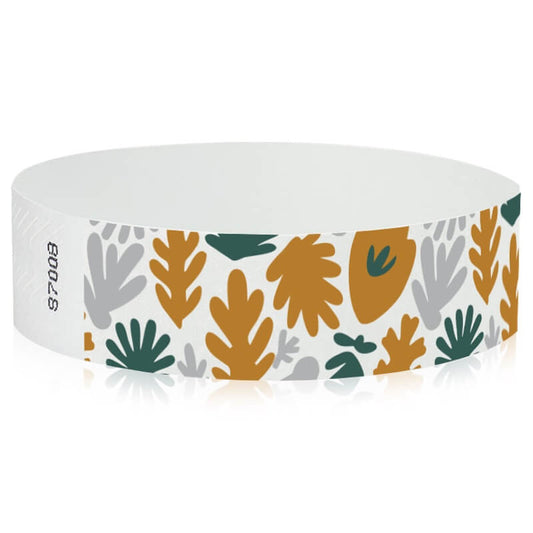White wristband with colourful leaf pattern in gold, silver and green - round version shown 