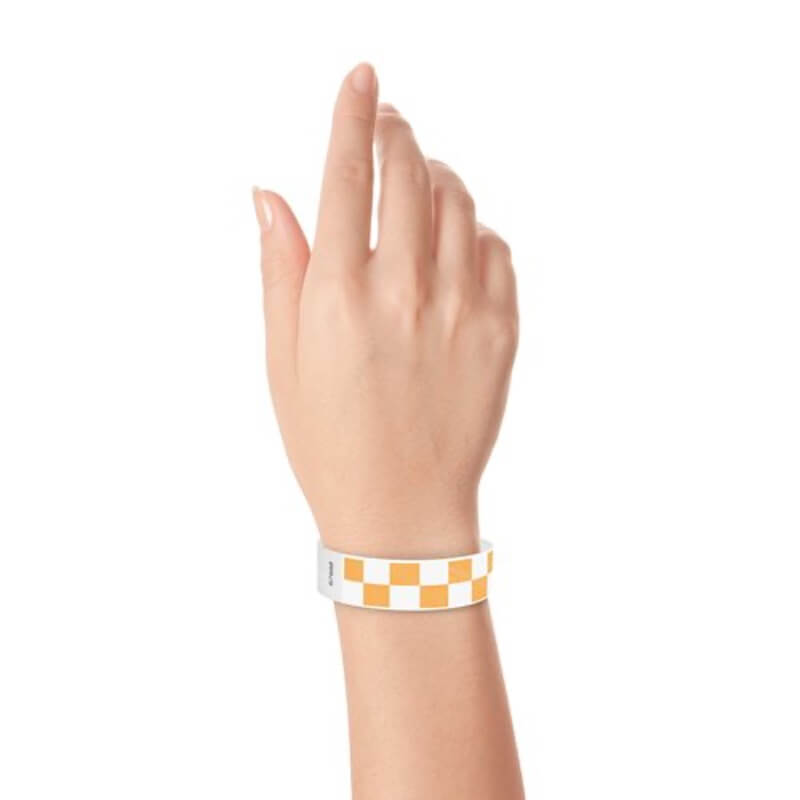 Hand wearing a neon orange and white checkered wristband 