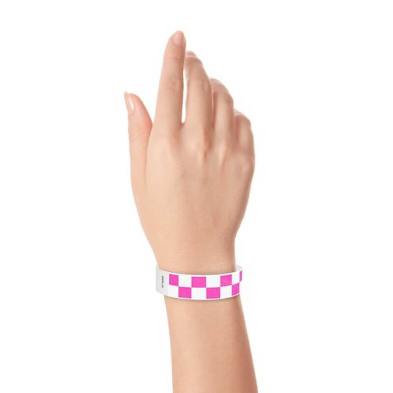 Hand wearing a neon pink and white checkered wristband 