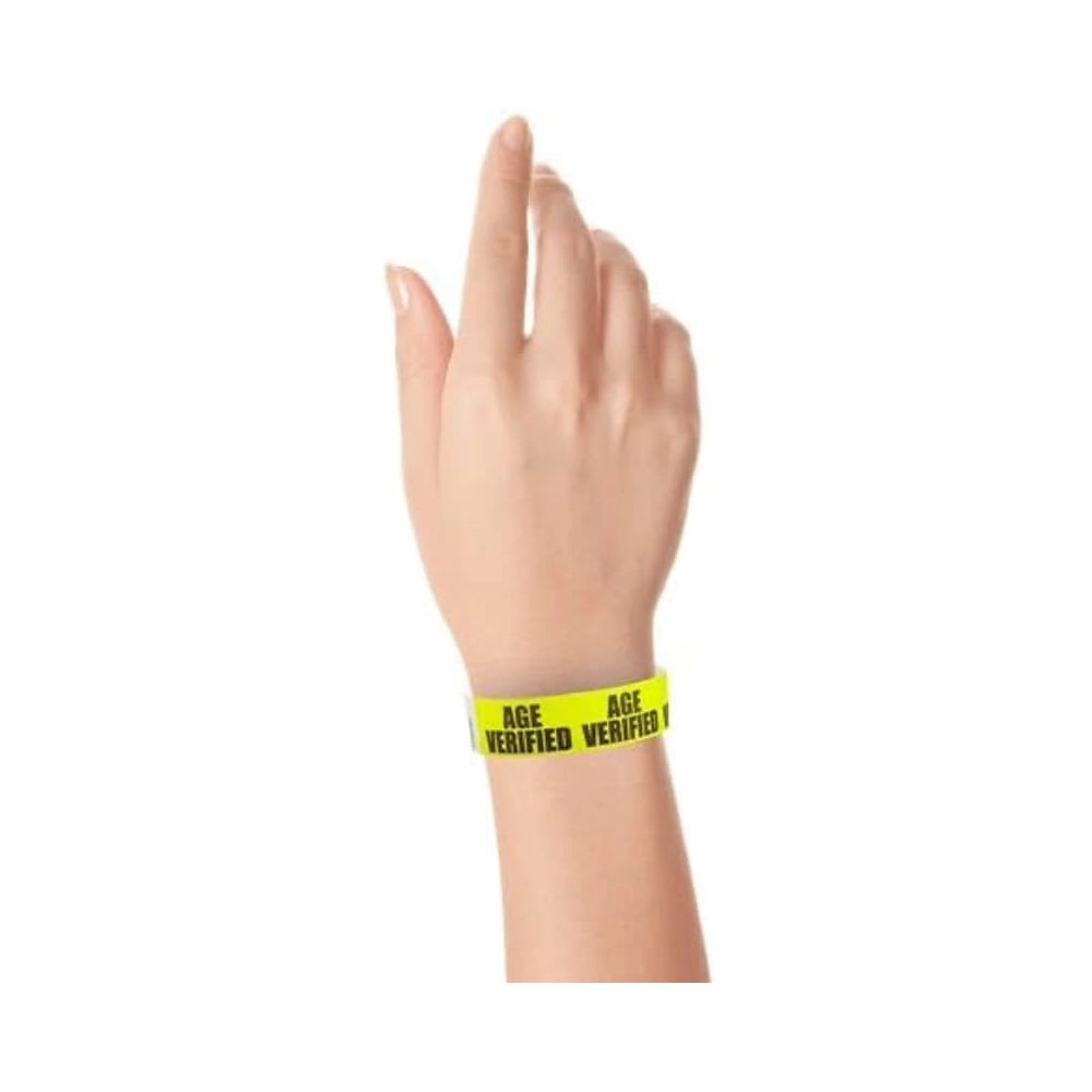 hand wearing neon yellow tyvek wristband with age verified text 