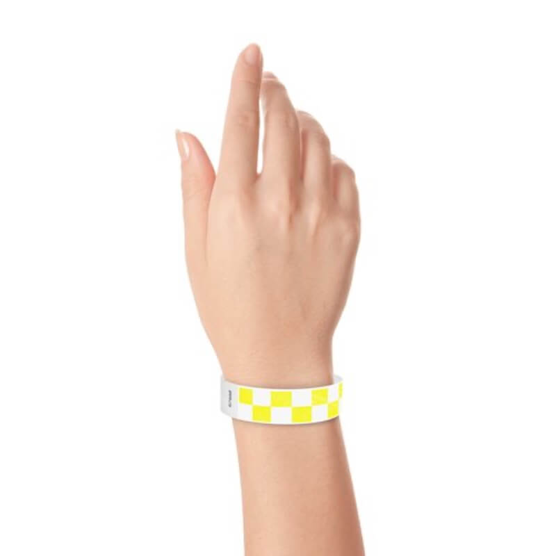 Hand wearing a neon yellow and white checkered wristband 