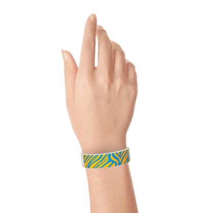 Wrist wearing neon orange tyvek wristband with neon blue zebra pattern 
