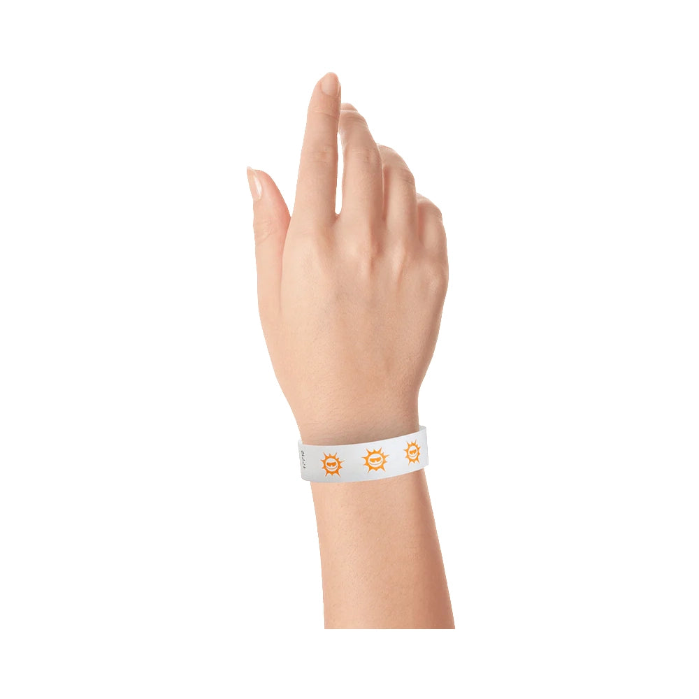 hand wearing white tyvek wristband with neon orange sun pattern repeated