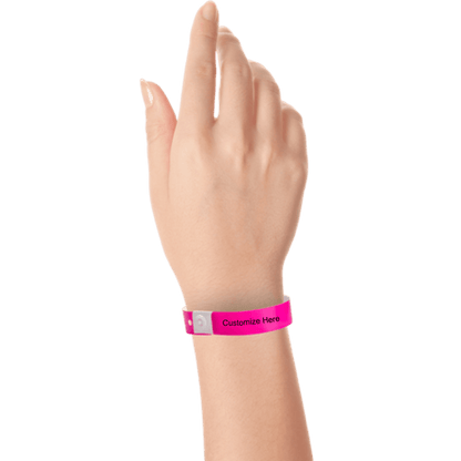 Hand wearing slim plastic wristband with a placeholder to show where you can customize the wristband shown in neon pink