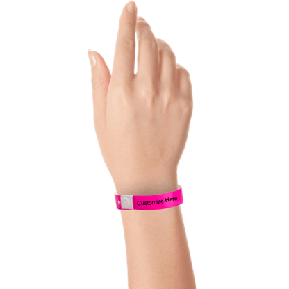 hand wearing plastic regular 3/4" wristband with a placeholder to show where you can customize the wristband in neon pink