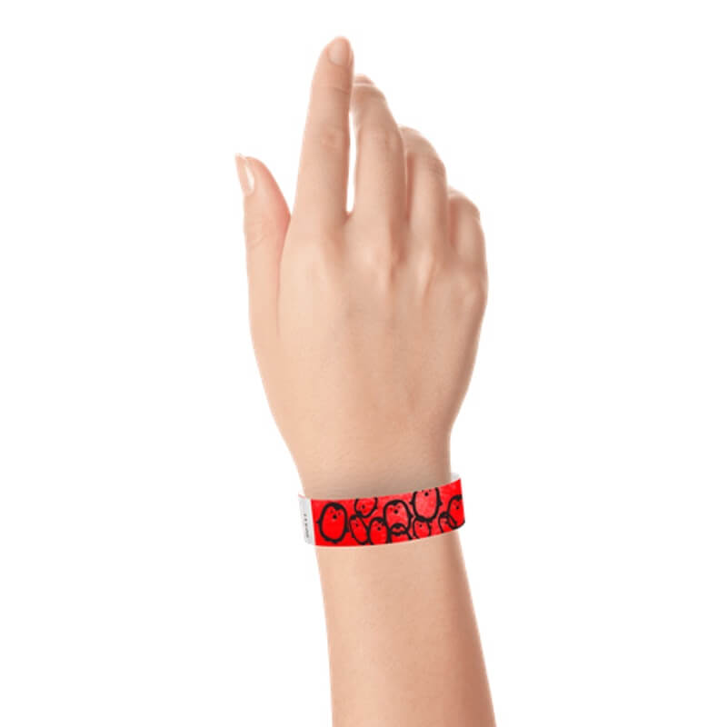 hand wearing a neon red tyvek wristband with a black penguin pattern