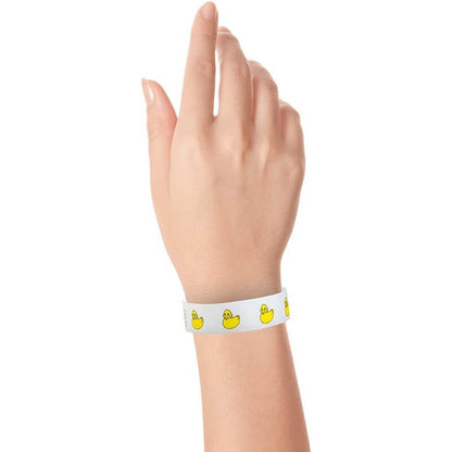 wrist wearing a white tyvek wristband with yellow rubber duckies repeating

