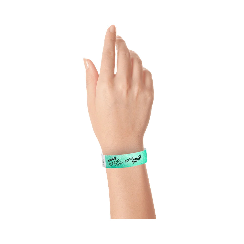 hand wearing an aqua tyvek wristband with sunday  text in black ink repeated