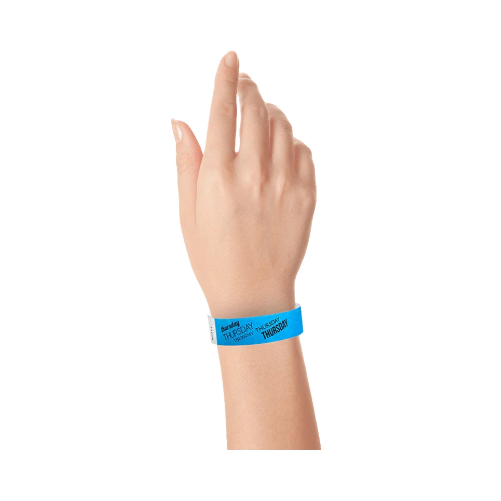 hand wearing neon blue tyvek wristband with thursday  text in black ink repeated