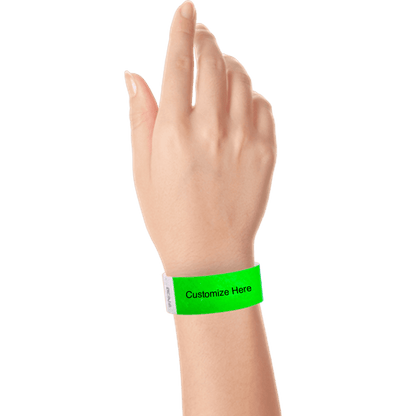hand wearing a neon green tyvek 1" solid wristband with a placeholder to customize with your text or logo