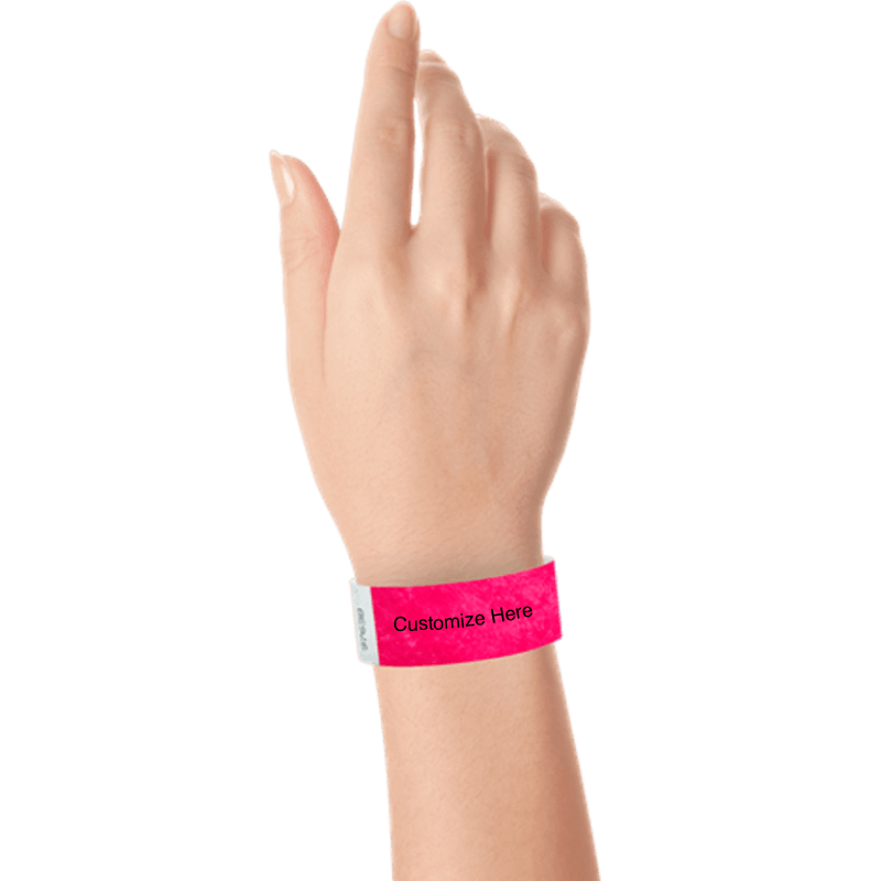 hand wearing a neon pink tyvek 1" solid wristband with a placeholder to customize with your text or logo