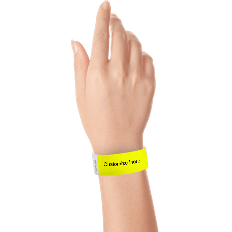 hand wearing a neon yellow tyvek 1" solid wristband with a placeholder to customize with your text or logo