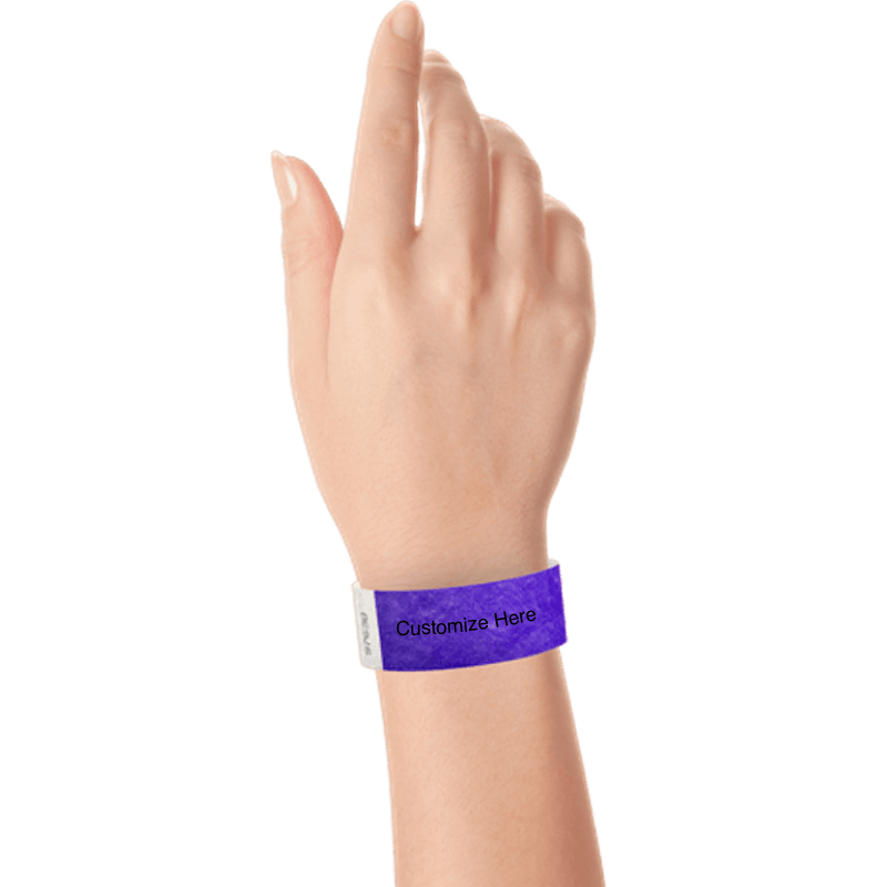 hand wearing a purple tyvek 1" solid wristband with a placeholder to customize with your text or logo