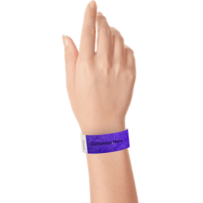 hand wearing a purple tyvek 1" solid wristband with a placeholder to customize with your text or logo