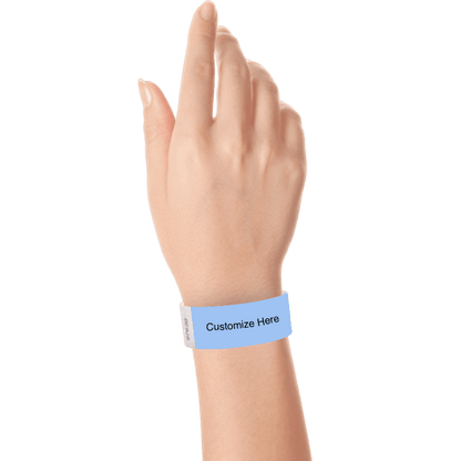 hand wearing a sky blue tyvek 1" solid wristband with a placeholder to customize with your text or logo