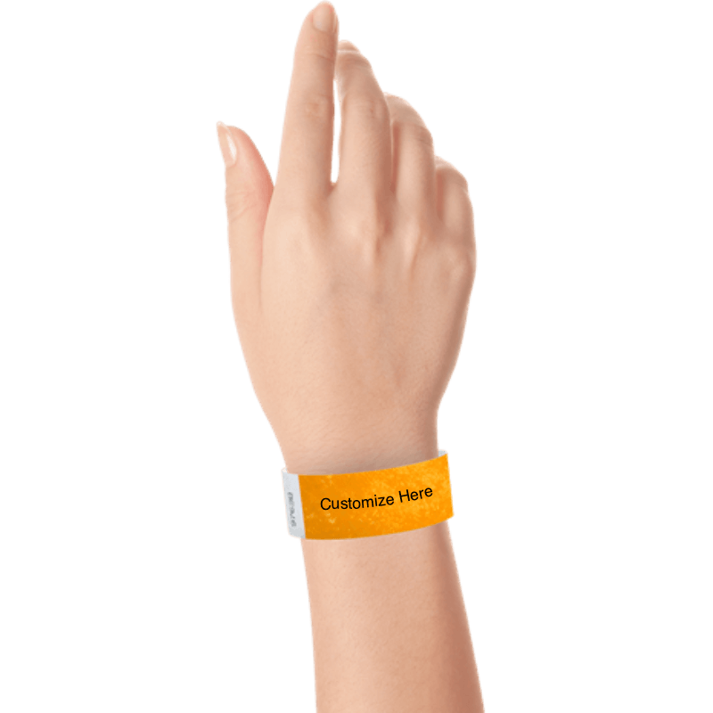 hand wearing a neon orange tyvek 1" solid wristband with a placeholder to customize with your text or logo 