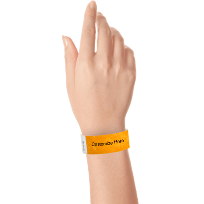 hand wearing a neon orange tyvek 1" solid wristband with a placeholder to customize with your text or logo 