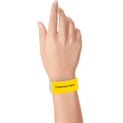 hand wearing a pantone yellow tyvek 1" solid wristband with a placeholder to customize with your text or logo 