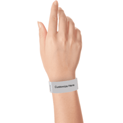 hand wearing a silver tyvek 1" solid wristband with a placeholder to customize with your text or logo